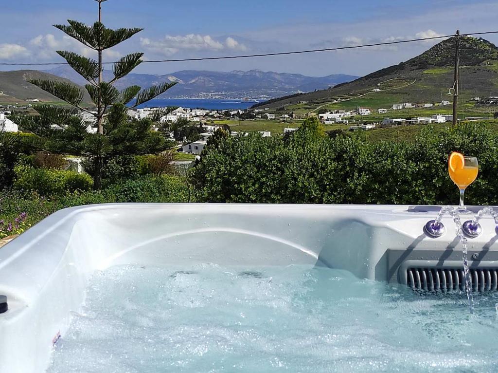 a bath tub filled with water with a wine glass in it at Irini's house with Jacuzzi in Dhragoulás