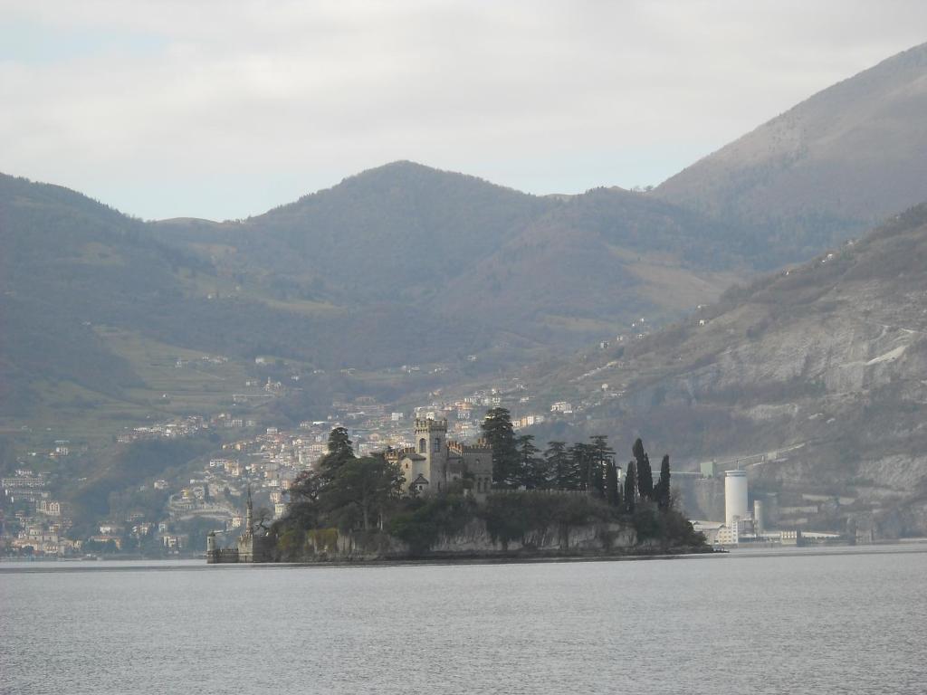a castle on an island in the middle of the water at Appartamento Al Ponte in Marone