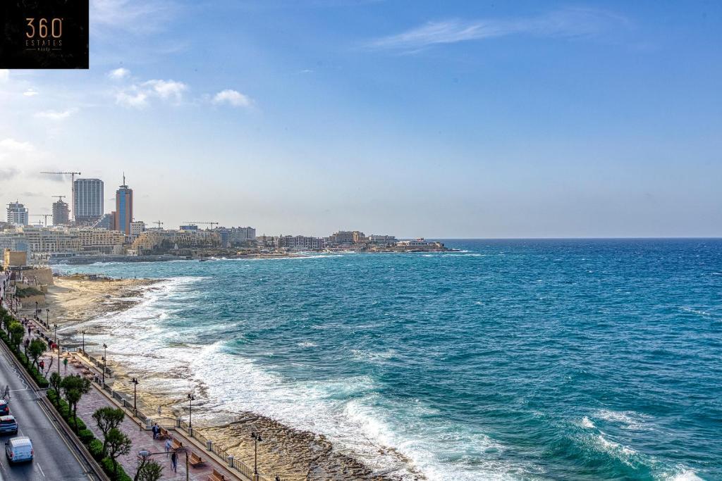 a view of the ocean with a city and a beach at Tower Road Sliema, 4BR APT with sensational views by 360 Estates in Sliema