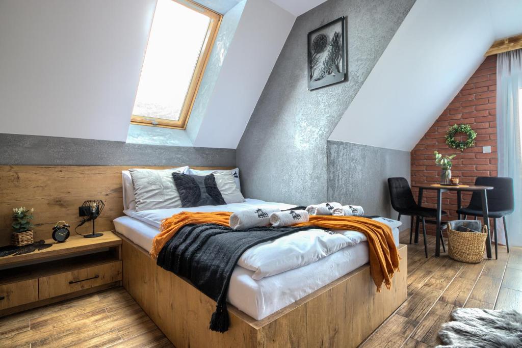 una camera da letto con un letto con una coperta arancione sopra di Wolfpack Guest House a Białka