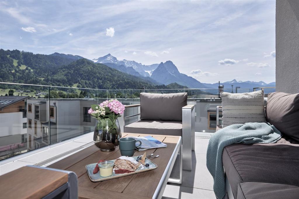 a balcony with a table and a view of mountains at Apartment BergRoof in Garmisch-Partenkirchen