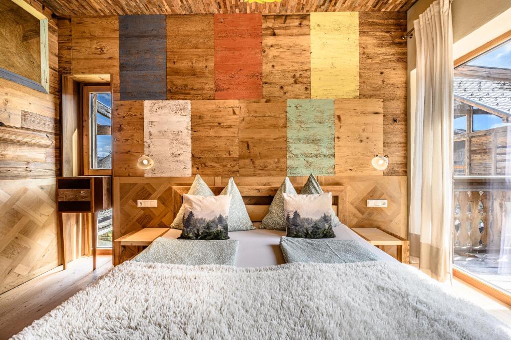 a bedroom with a bed and a wall of wood at der baum hideaway in Inzersdorf im Kremstal