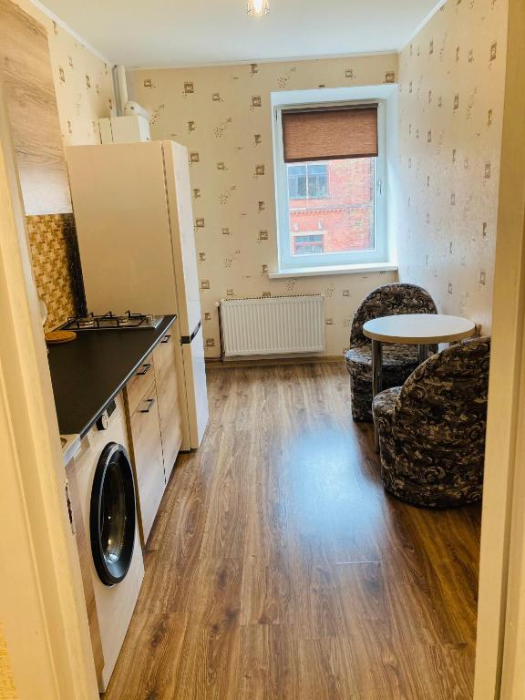 a kitchen with a refrigerator and a table in a room at Nākotnes street apartaments in Liepāja