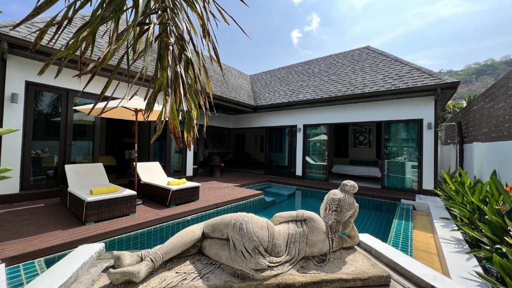 een zwembad met een standbeeld voor een huis bij Plunge Tropic Villas 2 Naiharn in Rawai Beach