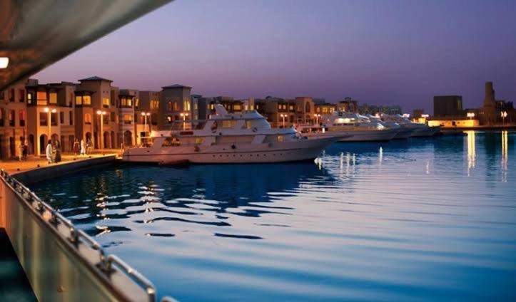 um grande barco está ancorado num porto à noite em One bedroom marina city portghalib em Port Ghalib