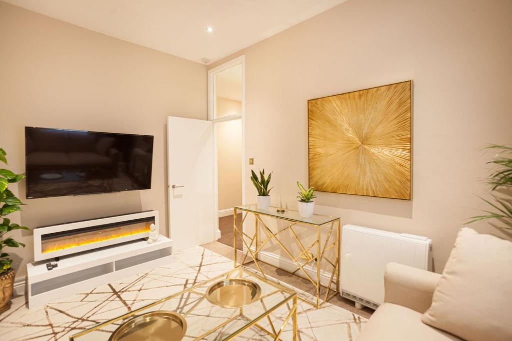 een woonkamer met een bank en een tv bij Beautifully decorated centrally located 2 bed flat in Brighton & Hove