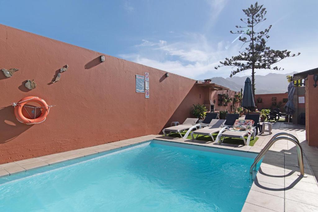 een zwembad naast een gebouw met stoelen bij Villa La Quinta de Vals in Valsequillo