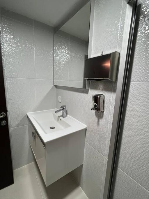 een witte badkamer met een wastafel en een spiegel bij Elit semtte muhteşem konumda daire in Antalya