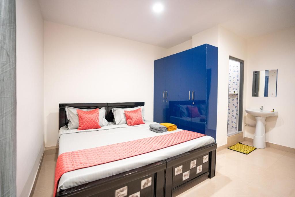 a bedroom with a bed with blue cabinets and a sink at Yellow Bells Signature HITEC City in Hyderabad