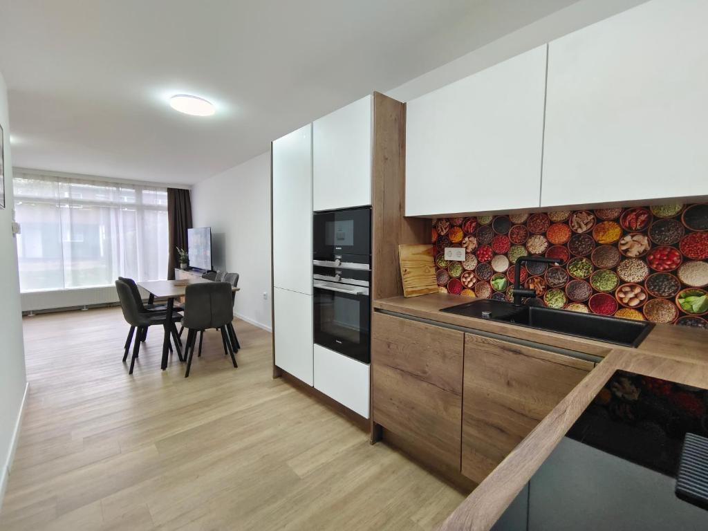 uma cozinha com armários brancos e uma mesa com cadeiras em City House - up to 8 Persons em Kapfenberg