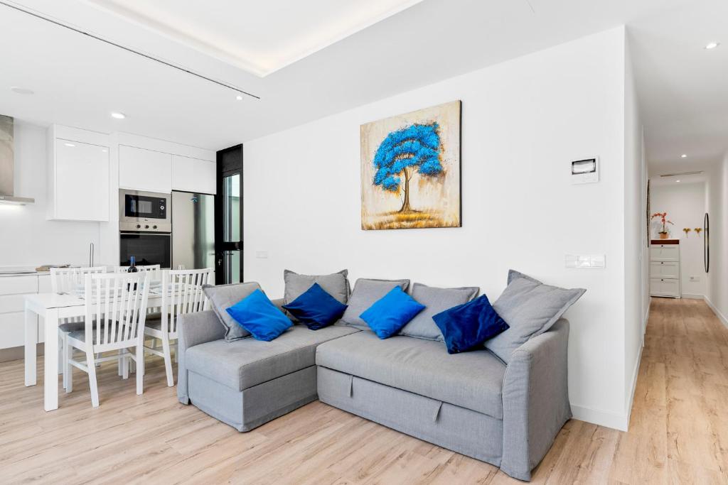 salon z szarą kanapą i niebieskimi poduszkami w obiekcie MEDANO4YOU Bogi's Holiday Home w mieście El Médano