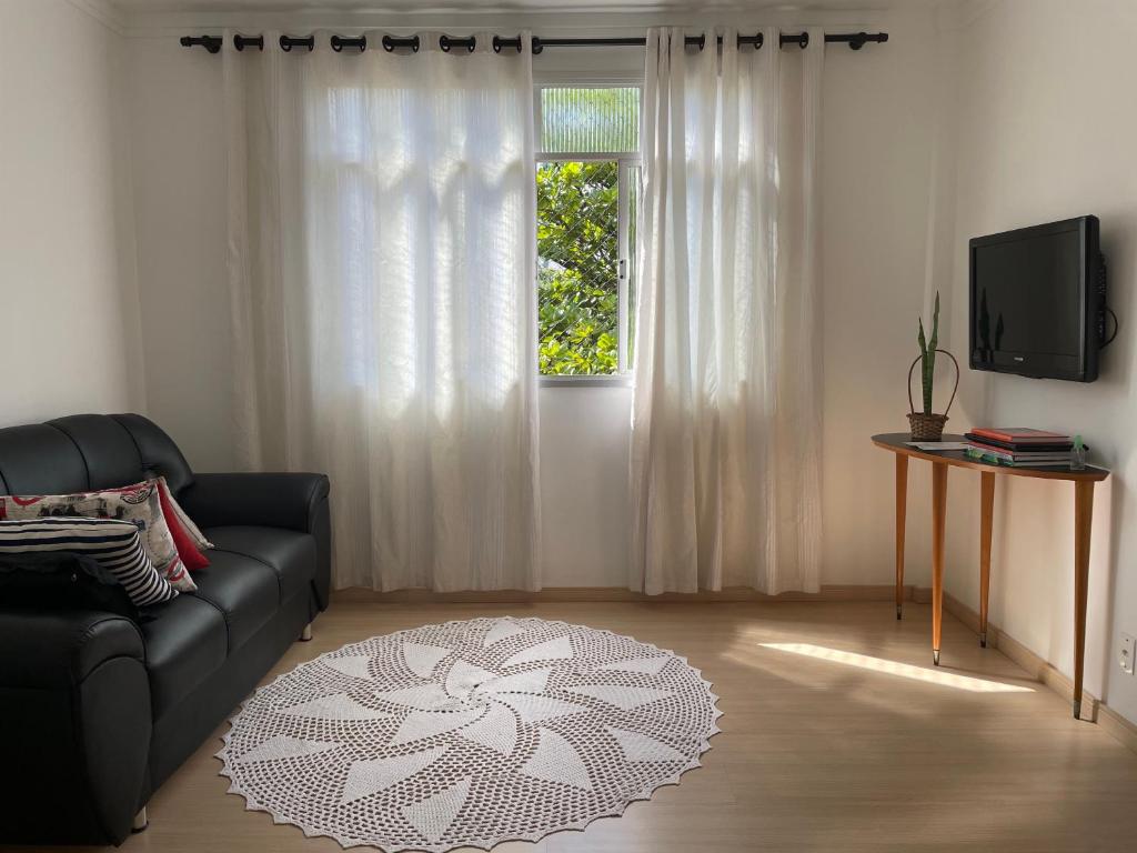 sala de estar con sofá y ventana en Apartamento Acolhedor e Bem Localizado en Vila Velha