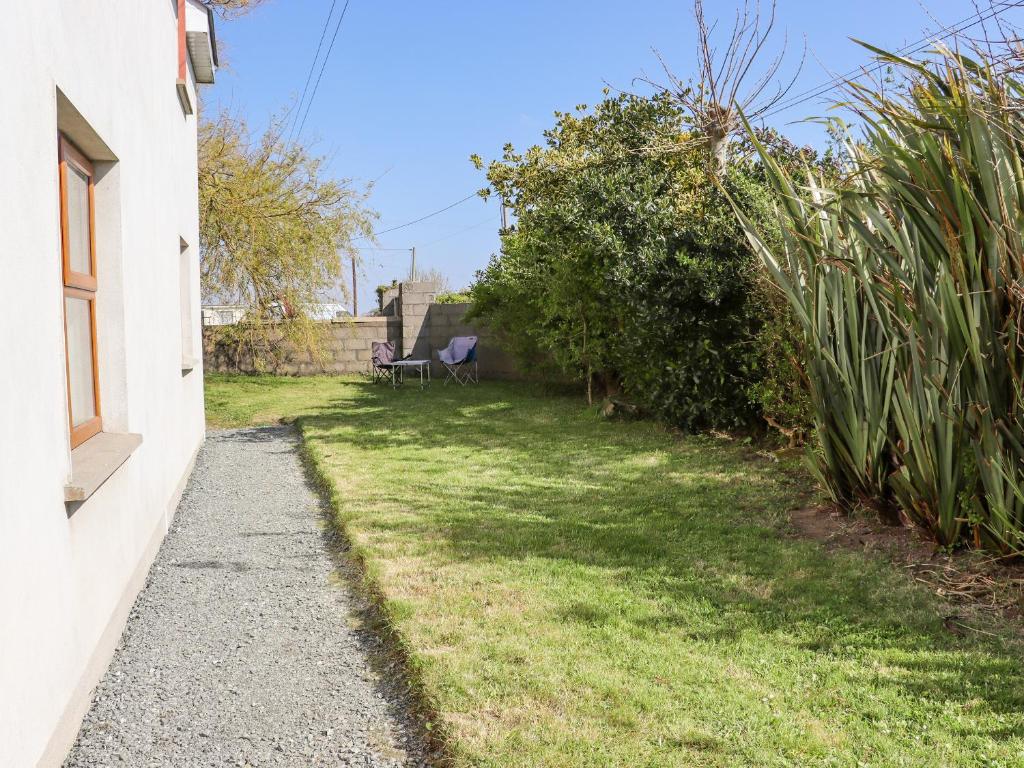 a garden next to a house with a bench at Wheatfield Lodge in Fethard on Sea