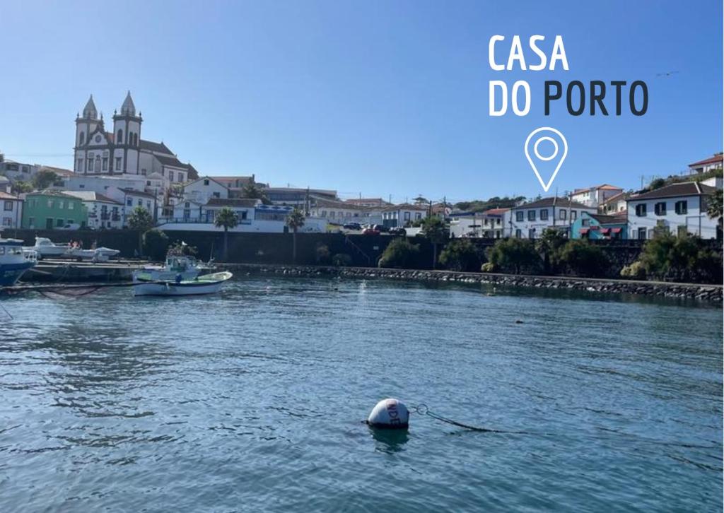 ein Boot in einem Fluss mit einer Stadt im Hintergrund in der Unterkunft Casa do Porto in Angra do Heroísmo