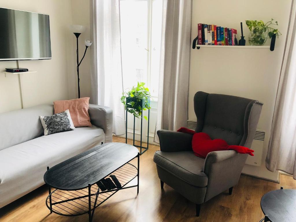 a living room with a couch and a chair at Adam&Eva Rooms in Prague