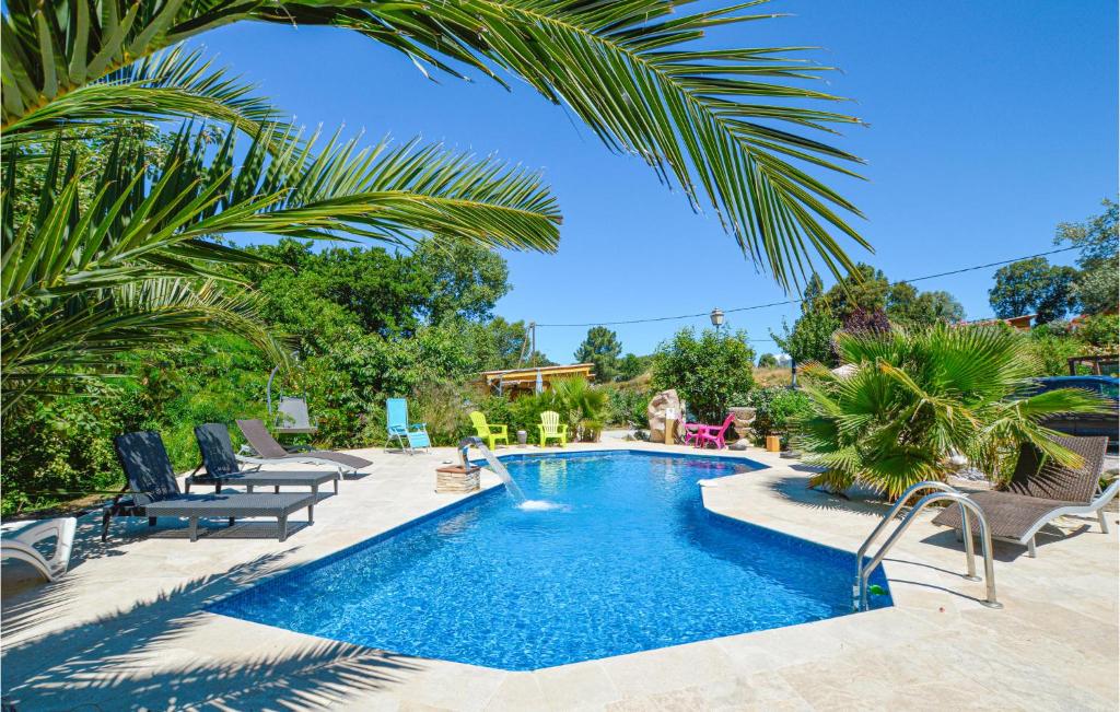 Petreto-Bicchisano的住宿－Beautiful Home In Petreto Bicchisano With Heated Swimming Pool，庭院内的游泳池,带椅子和树木