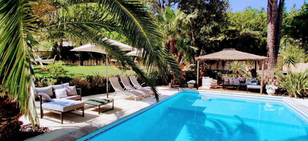 una piscina con sillas y un cenador en Maison Prestige Saint Tropez by Roberto Geissini, en Grimaud