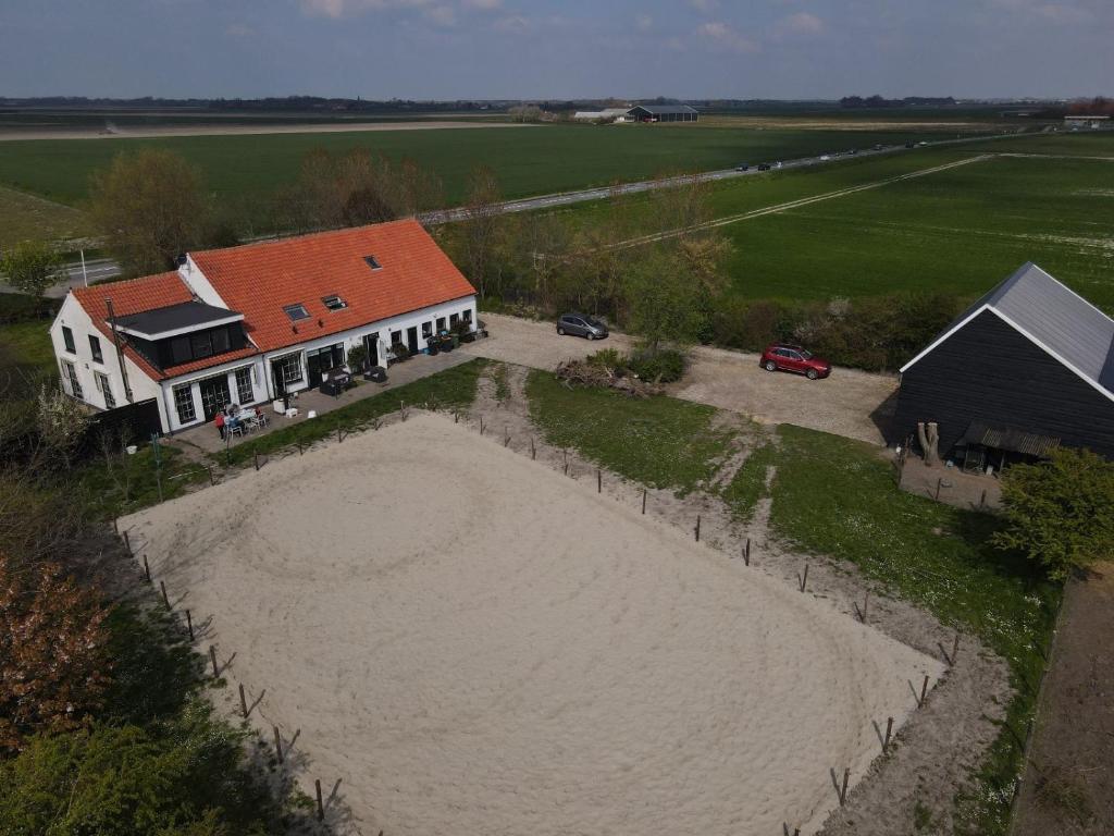an aerial view of a house with a large beach at Het Tinkerparadijs, paarden, rust en ruimte. in Burgh Haamstede