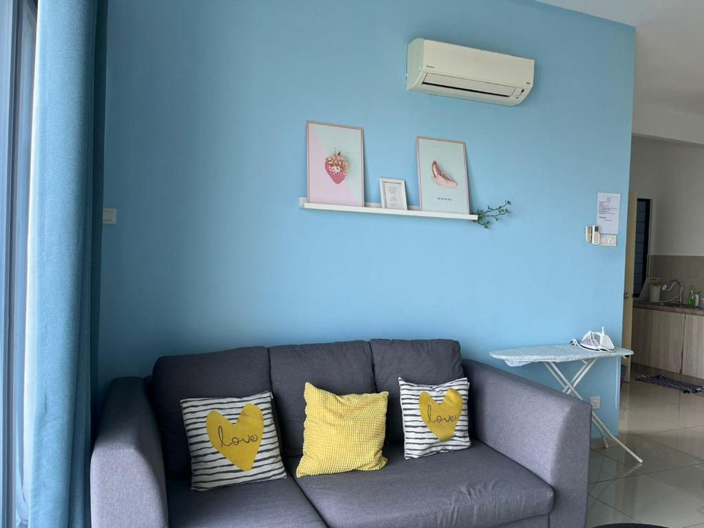 a blue room with a couch with yellow pillows at Atlantis Sea View Unit in Malacca