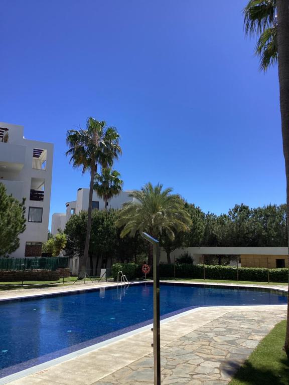a swimming pool with palm trees next to a building at Alamar Cala Mijas Sun&Beach in La Cala de Mijas