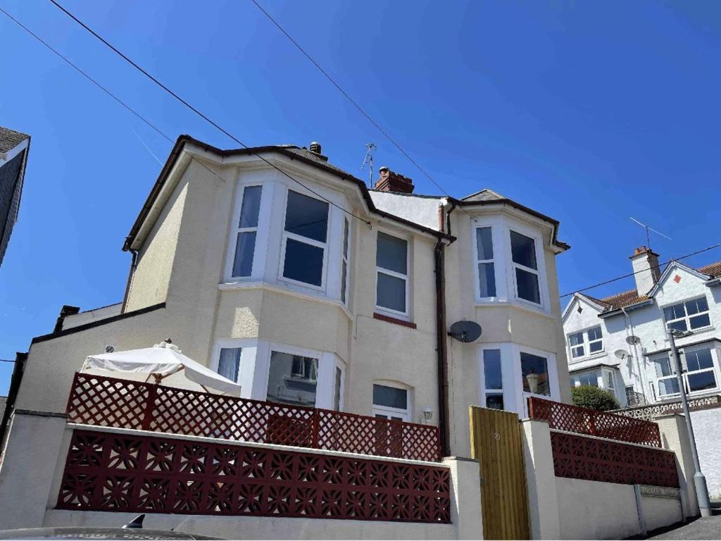 a large white house with a balcony on a street at Charming 2-Bed House in Dawlish town centre in Dawlish