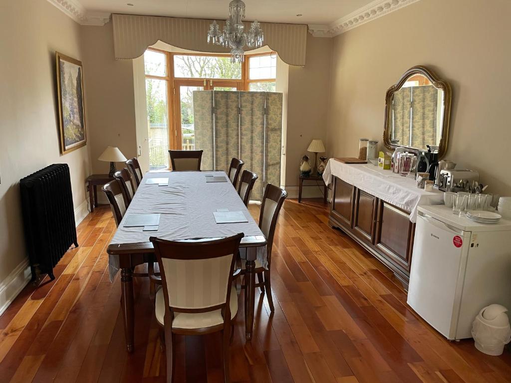 un comedor con una mesa larga y sillas en Taylors Hill Luxury Guest House en Galway