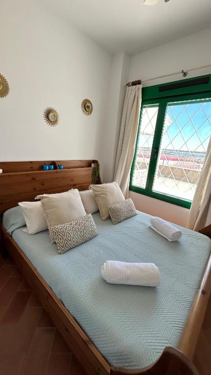 a large bed with two pillows and a window at Brisa Marinera in El Rompido