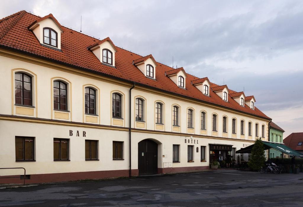 un gran edificio blanco con techo rojo en Hotel Rychta Netolice, en Netolice