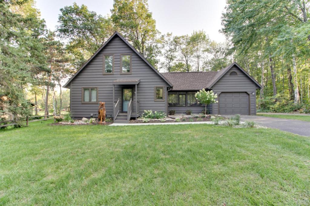 a home with a black house with a yard at Breezy Point Cabin Deck with Golf Course Views! in Pequot Lakes
