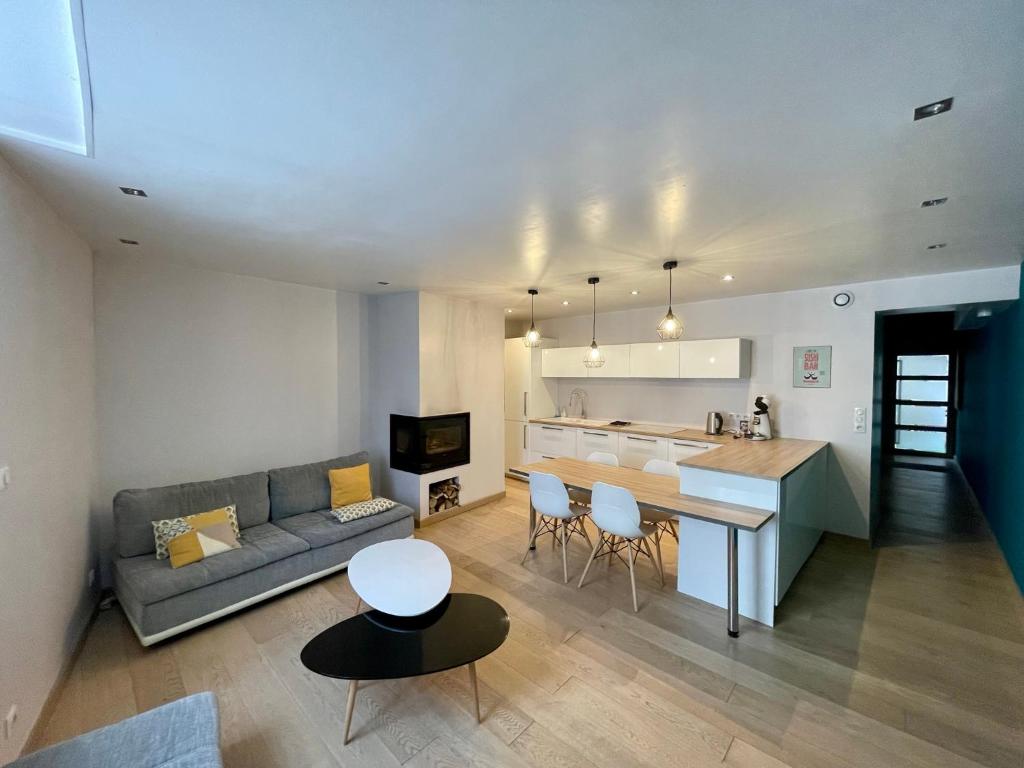 a living room and kitchen with a couch and a table at Appartement au coeur d'Arbois in Arbois