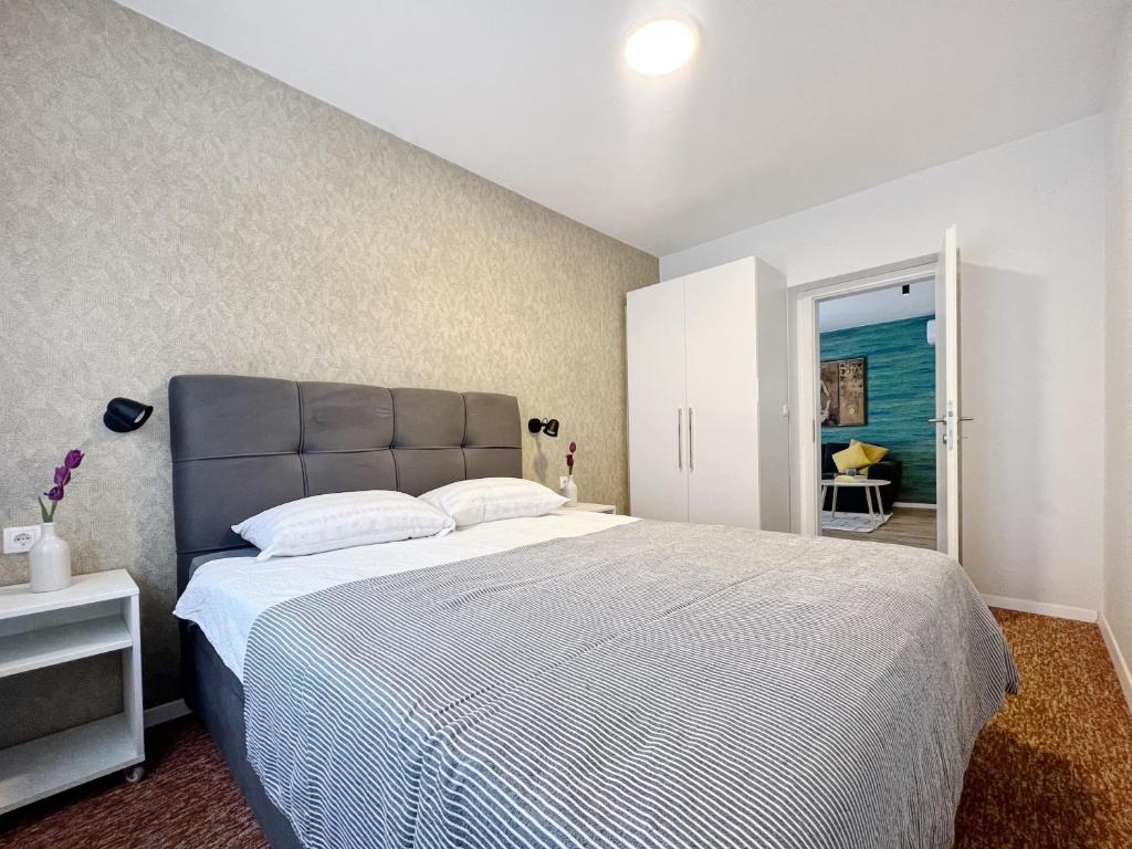 una camera con un grande letto con testiera blu di Apartments Valerian a Novigrad Istria