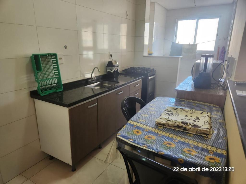 une petite cuisine avec une table et un évier dans l'établissement Apartamento novo Vila Guilhermina, à Praia Grande