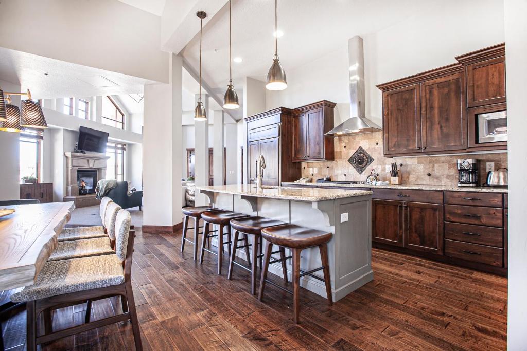 a large kitchen with wooden cabinets and bar stools at Hyatt at the Canyons by Lespri Management in Park City