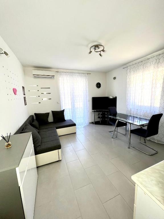 a living room with a couch and a table at Apartman Solin 3, parking in Solin