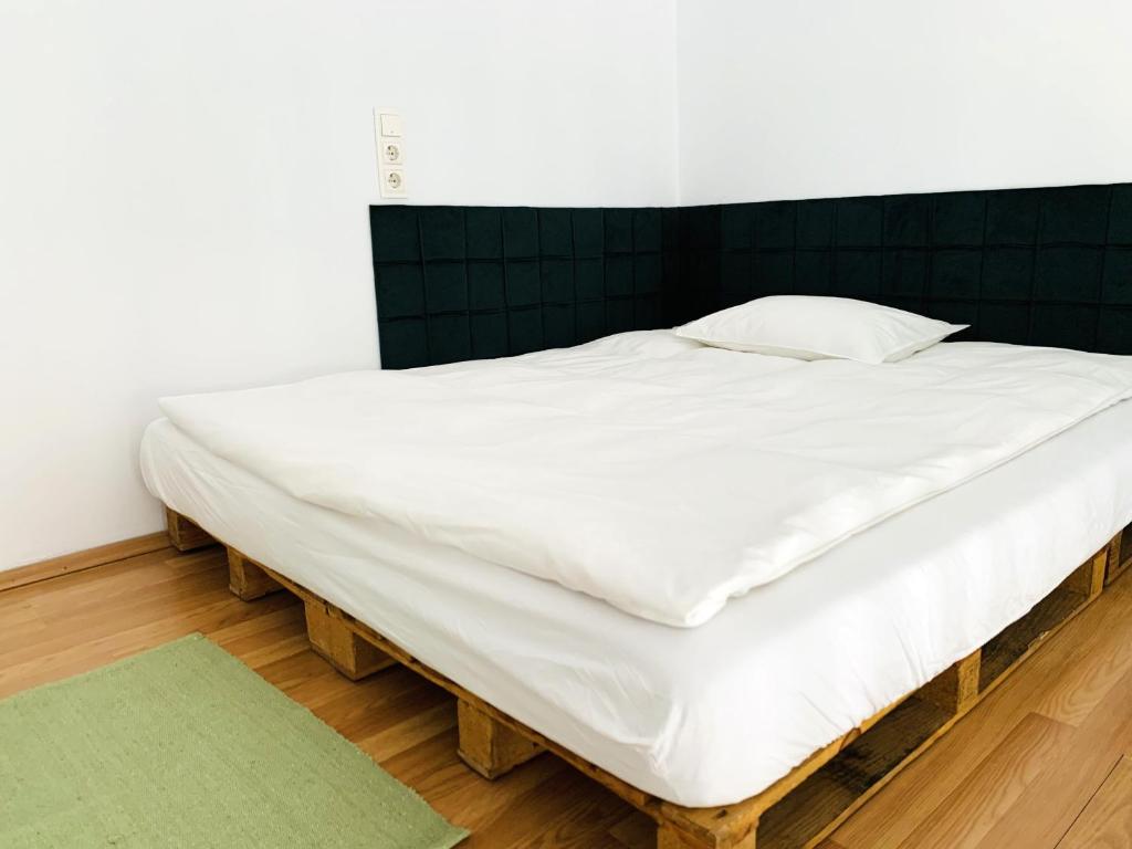 un grand lit blanc avec une tête de lit en bois dans l'établissement Central Cozy Apartment, à Cluj-Napoca