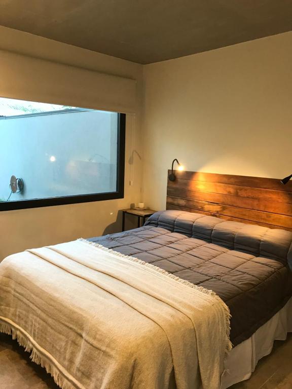 1 dormitorio con cama y ventana grande en AIKEN JARDIN con cochera en San Martín de los Andes