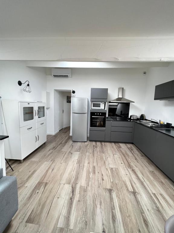 une grande cuisine avec des appareils blancs et du parquet dans l'établissement appartement T2 au centre ville de Sanary sur mer, à Sanary-sur-Mer