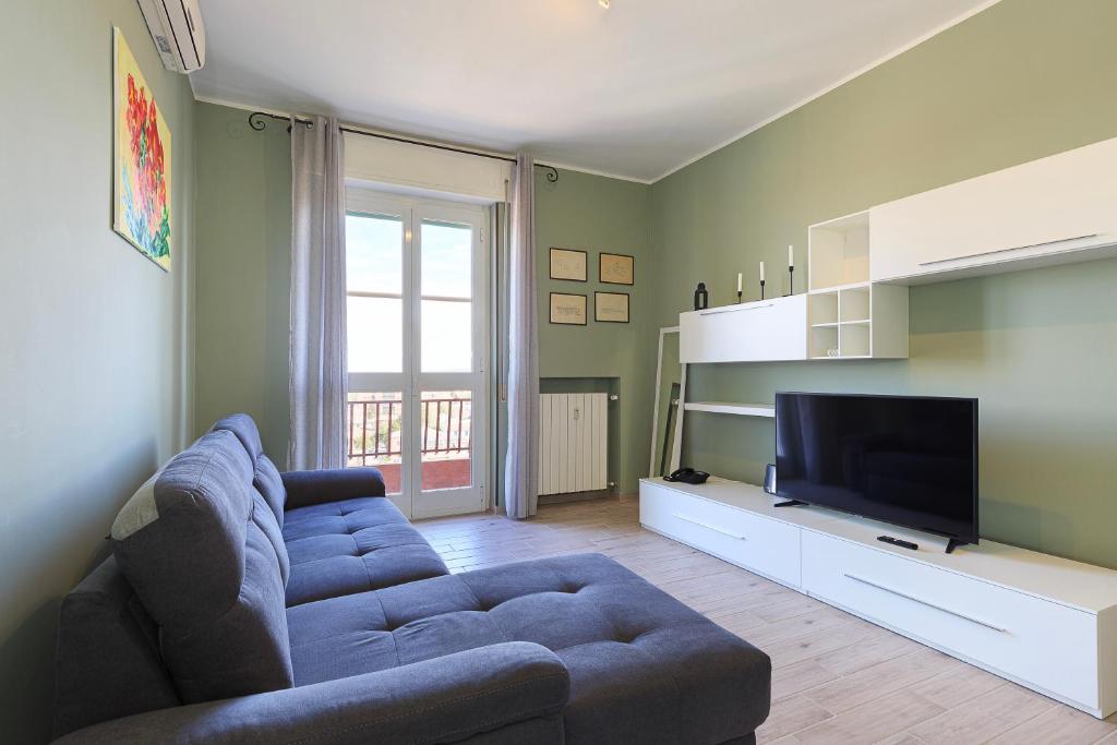 un soggiorno con divano blu e TV di Appartamento Dante a Novi Ligure