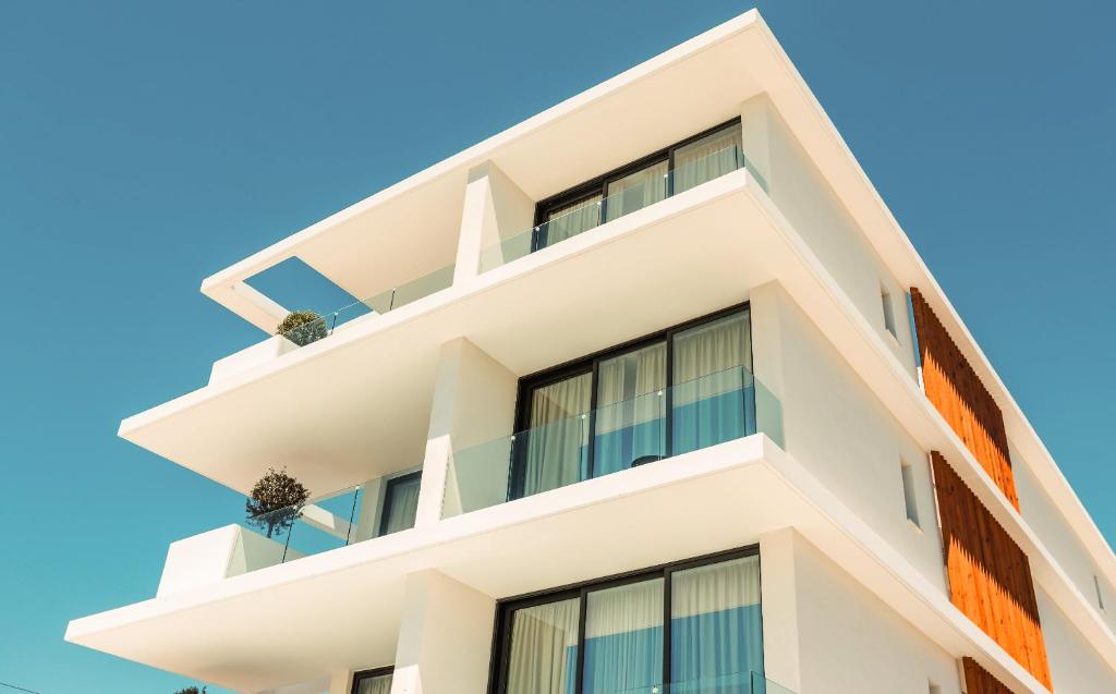 Regency Boutique Hotel Holiday Suites في بافوس: مبنى بشرفات مقابل السماء الزرقاء