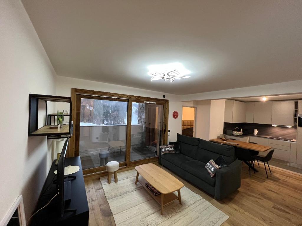 un salon avec un canapé et une table dans l'établissement Résidence de l'Ariondaz - Courchevel, à Courchevel