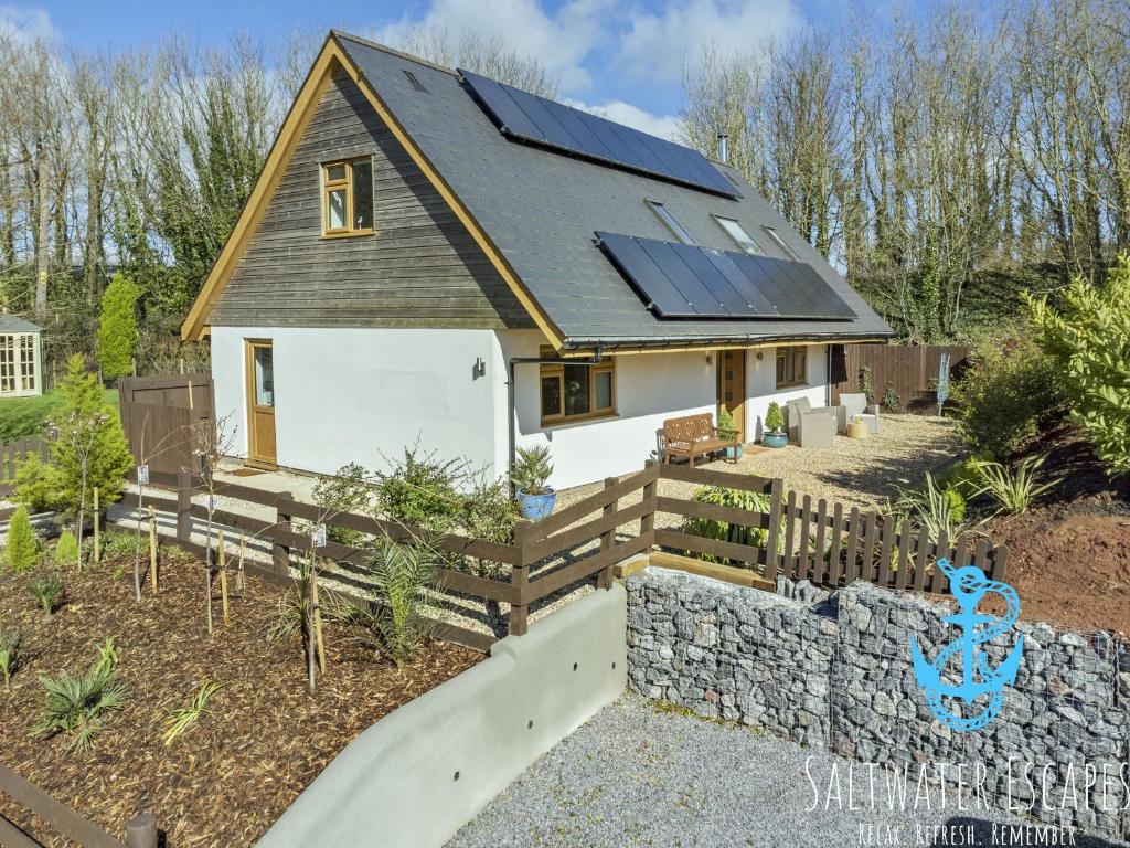 a house with solar panels on the roof at Boundary Cottage - Spacious Homely Cottage With Log Burner and Garden in Marldon