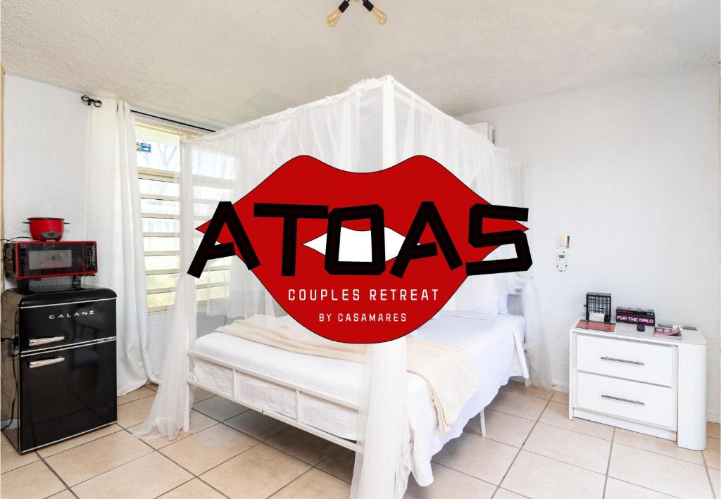 a room with a white bed with a red sign on it at ATOAS - Lovely Vacation Retreat with Pool and Jacuzzi 5 min to Boqueron and Beaches in Cabo Rojo