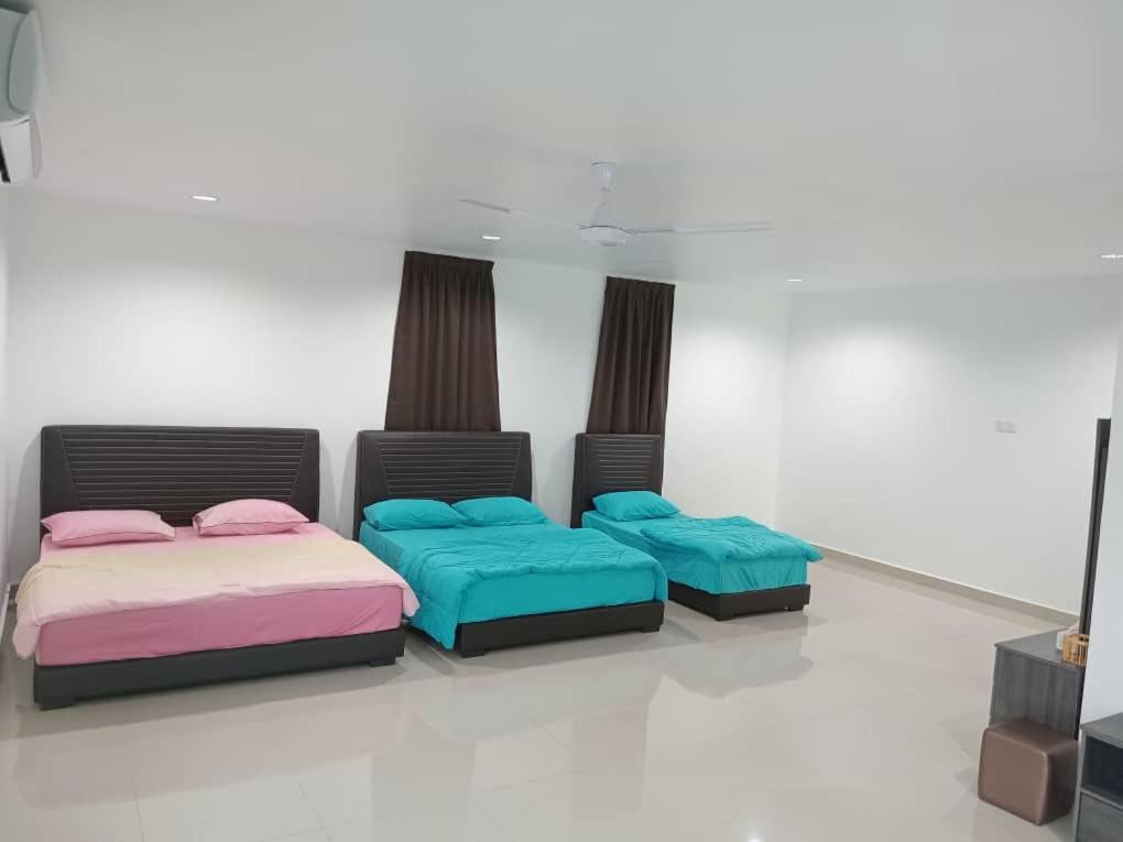 2 camas con almohadas en una habitación en EMERALD VILLA HOMESTAY DUNGUN en Batu Lima