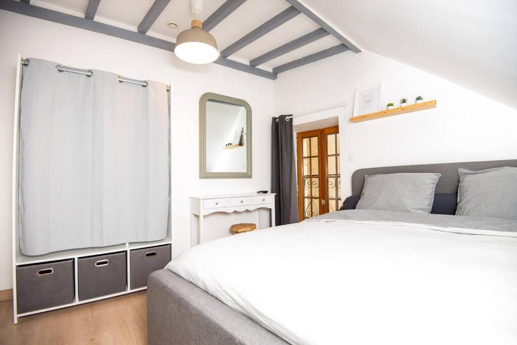 biała sypialnia z łóżkiem i lustrem w obiekcie Maison de charme en Bourgogne w mieście Vincelottes
