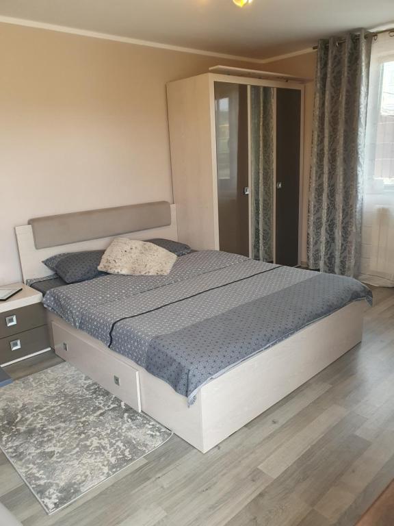 - une chambre avec un grand lit et une couette bleue dans l'établissement Vila Sunset, à Galaţi