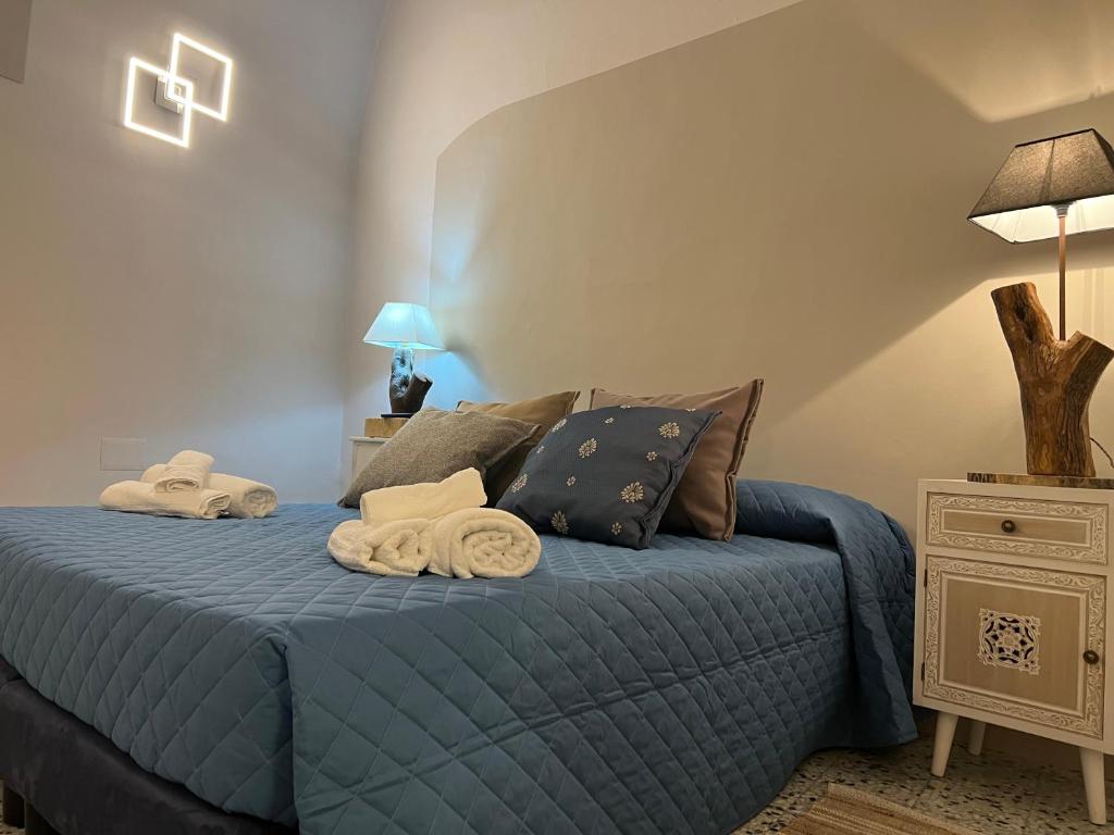 a bedroom with a blue bed with towels on it at Le Dimore Del Gufo - La Cattedrale in Venosa