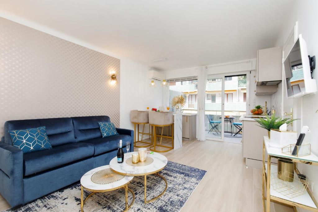 un salon avec un canapé bleu et une table dans l'établissement Perle Dorée YourHostHelper, à Cannes