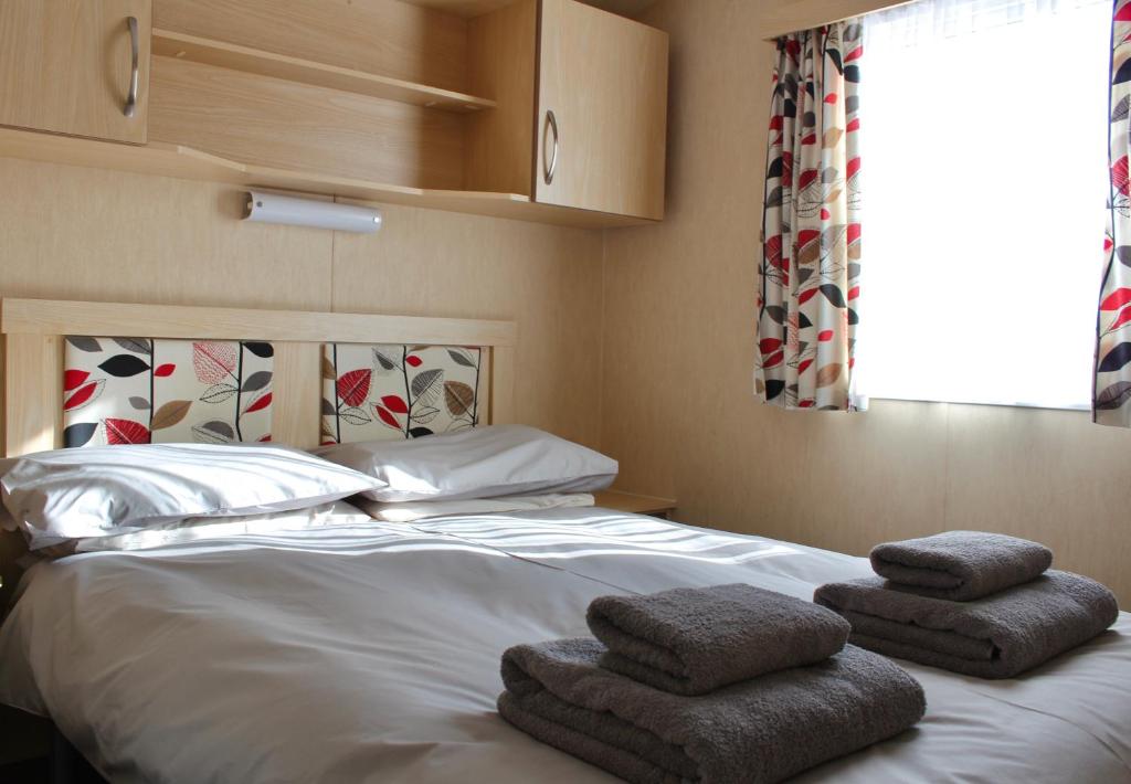 a bedroom with a bed with towels on it at Crannich Holiday Caravans in Killichronan