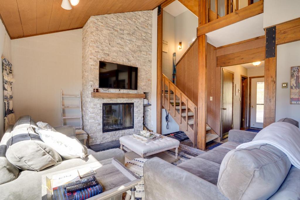 a living room with a fireplace and a stone wall at Charming Townhome - Walk to Greek Peak Mountain! in Cortland