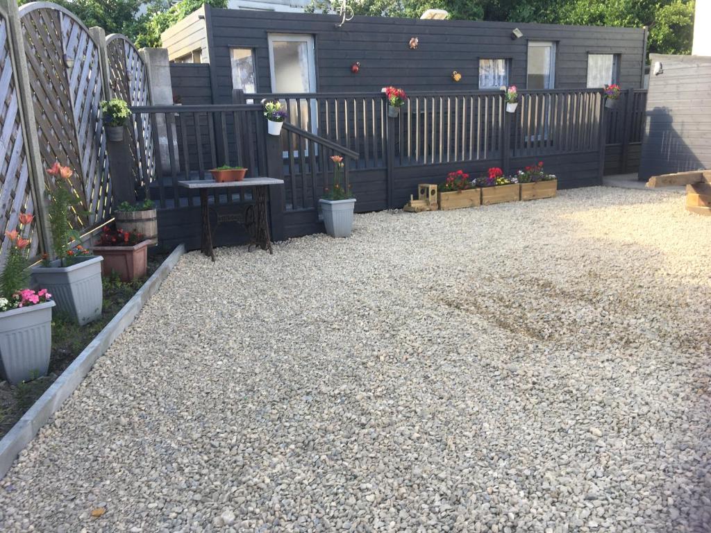 a gravel patio with a fence and a table and flowers at The Caravan at Loggans Lodge in Hayle